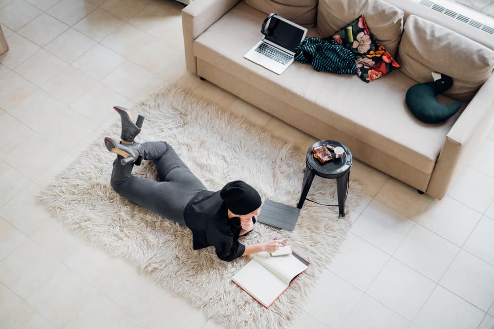 Woman laying on home floor doing work