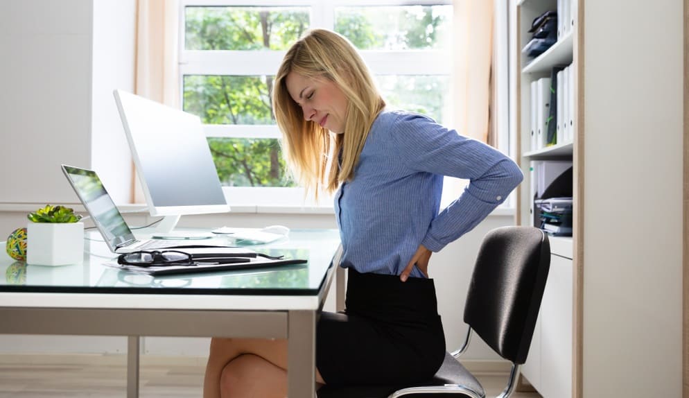 Businesswoman Suffering From Back Pain In Office