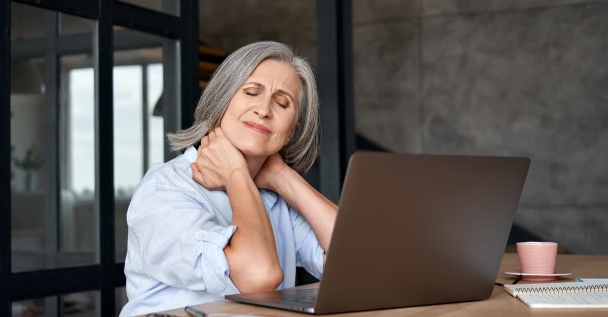 stressed old mature business woman suffering from fibromyalgia neckpain