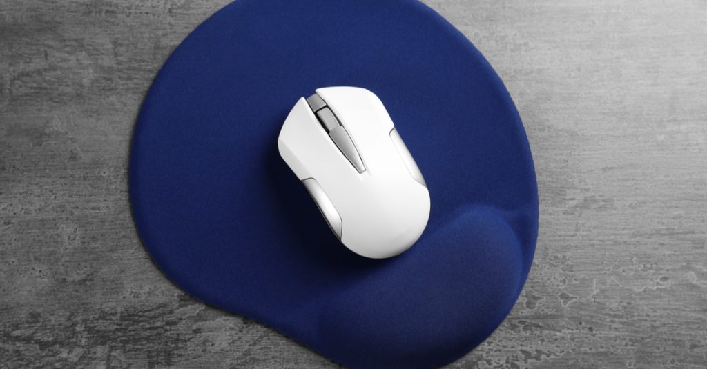 Blank mat and wireless mouse on textured background