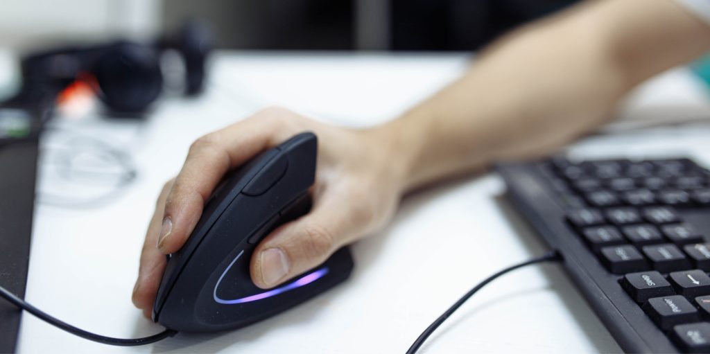 man’s hand, a vertical ergonomic computer mouse-joystick is used